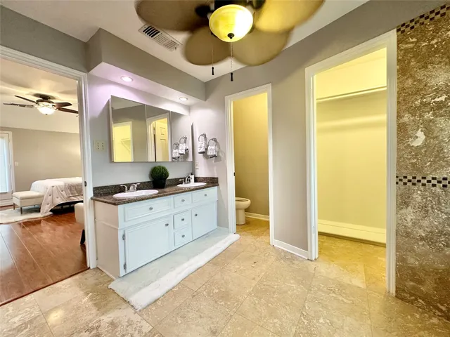 a spacious bathroom with a granite countertop sink and a mirror