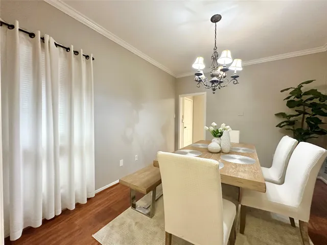 a dining room with furniture a chandelier and wooden floor