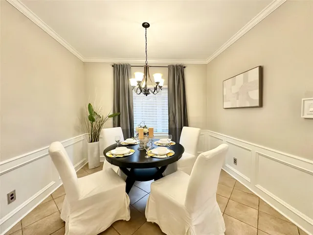 a view of a dining room with furniture and chandelier