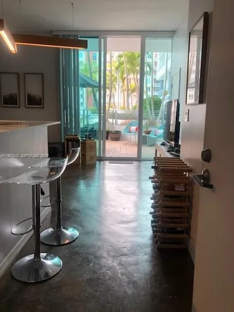 a living room with furniture and a floor to ceiling window