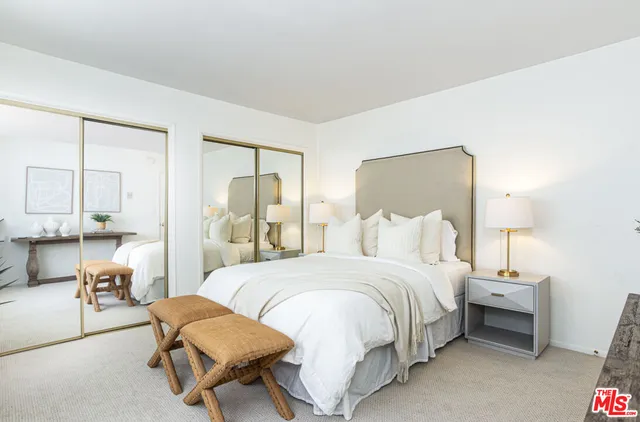 a spacious bedroom with a bed a table and painting