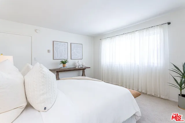a bedroom with wooden floor and window