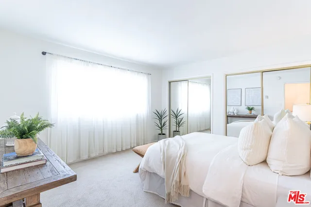 a bedroom with a bed and a potted plant