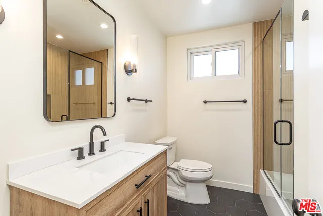 a bathroom with a toilet a sink and mirror