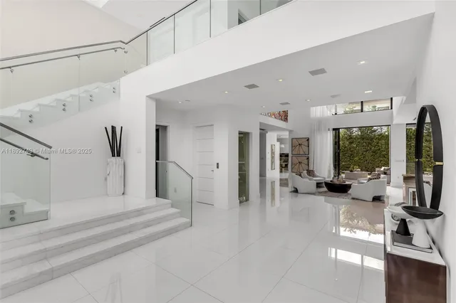 a view of staircase with white walls and a chandelier