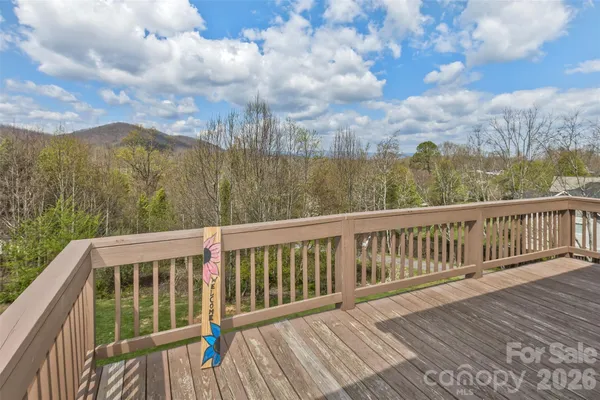 a view of balcony with wooden floor and fence