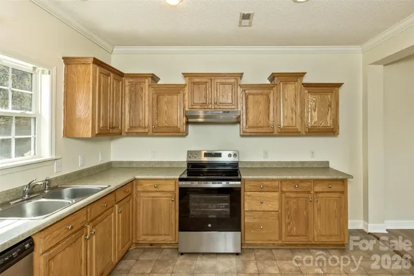 a kitchen with stainless steel appliances granite countertop a sink stove and cabinets
