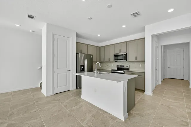 a kitchen with stainless steel appliances granite countertop a refrigerator oven a sink and dishwasher