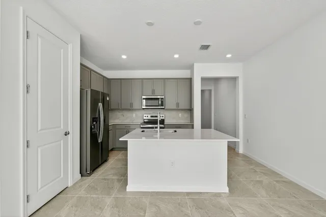 a view of a kitchen with a sink refrigerator and window