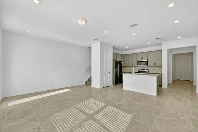a view of kitchen with kitchen island white cabinets and refrigerator