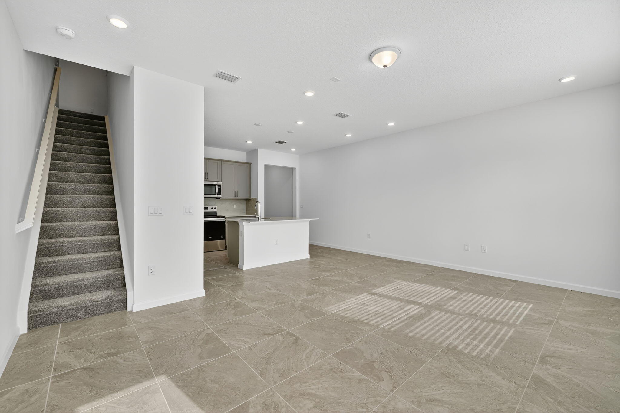 7596 Southwest Linus Lane Stuart, FL 34997 - Photo 8 of 26 a view of kitchen and hallway with stairs