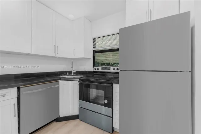a kitchen with granite countertop cabinets stainless steel appliances and a counter space