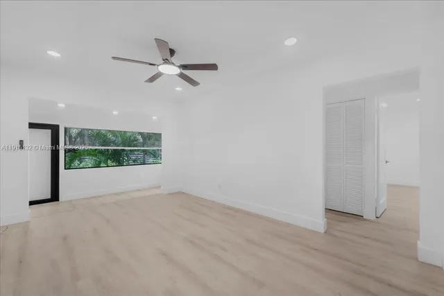 an empty room with window and ceiling fan