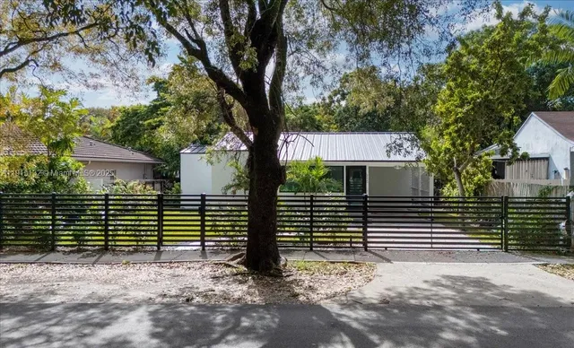 a view of a house with a tree in the yard