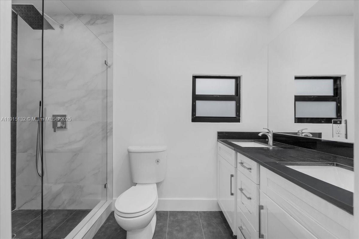 5220 Southwest 6th Street Miami, FL 33134 - Photo 38 of 56 a bathroom with a granite countertop sink toilet and shower