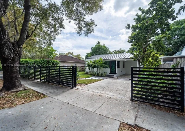 a view of house with backyard and a garden