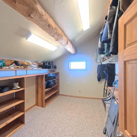 a view of walk in closet with clothes and shoes