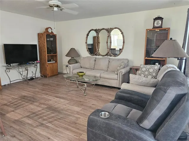 a living room with furniture a lamp and a large window