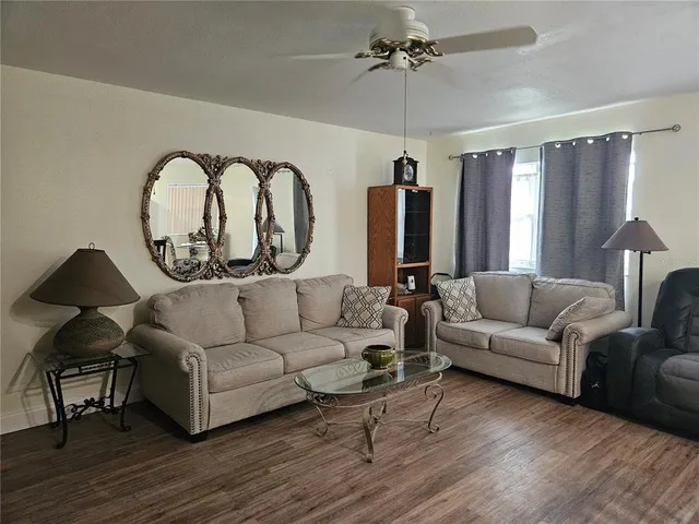 a kitchen with a refrigerator a stove and a dining table with wooden floor