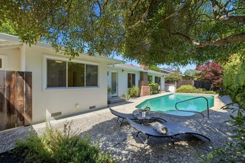 a view of a house with backyard sitting area and garden