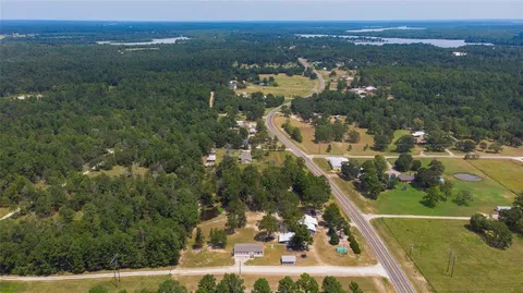 an aerial view of residential houses with outdoor space and trees