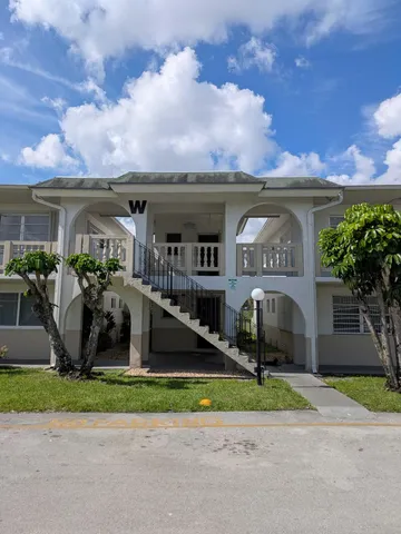 a view of house with a yard and a street