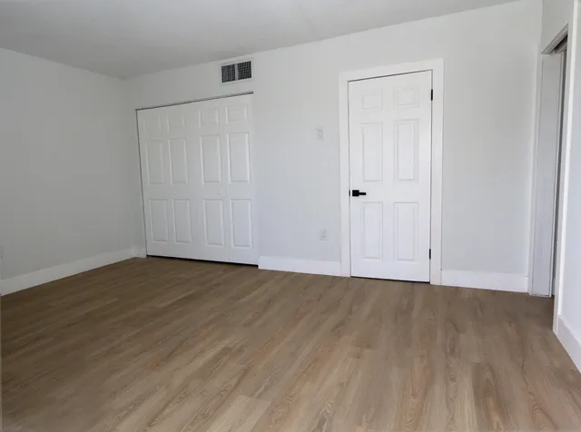 a view of an empty room with wooden floor