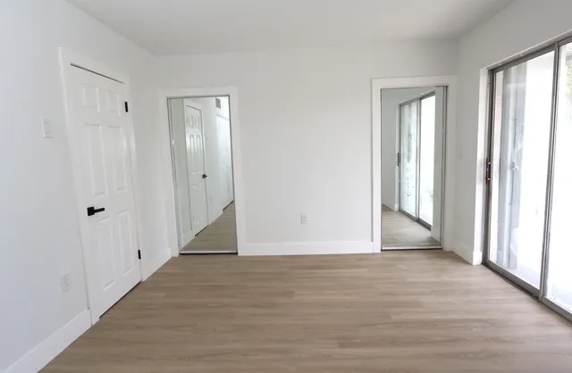 a view of an empty room with wooden floor