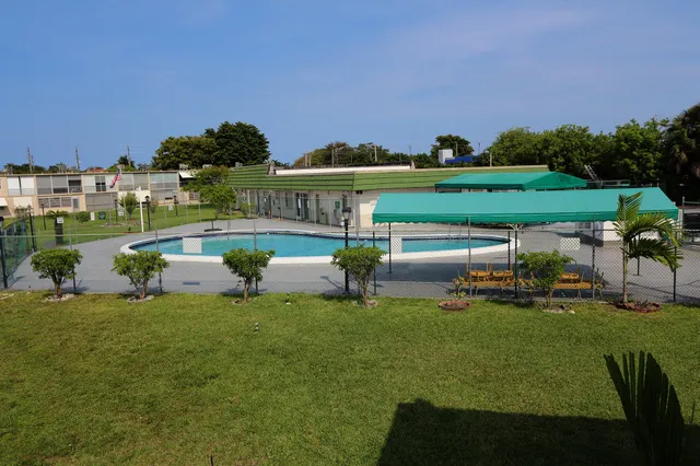 a view of a swimming pool and lounge chairs in back yard