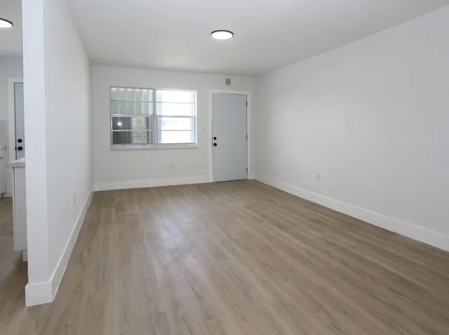wooden floor in an empty room with a window