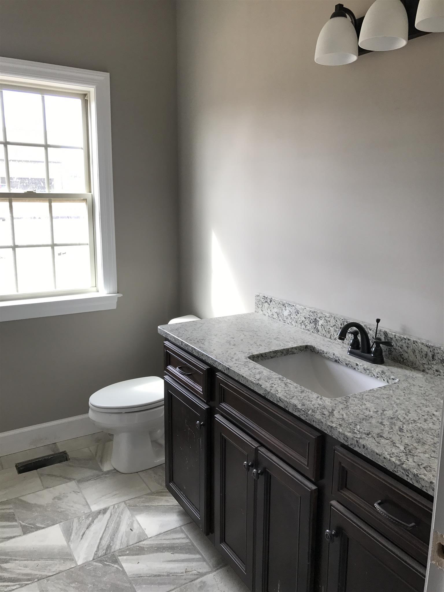 479 Halltown Road Portland, TN 37148 - Photo 18 of 25 a bathroom with a granite countertop sink and a toilet
