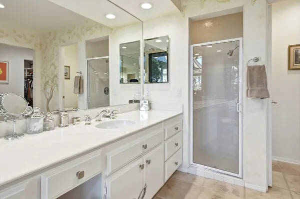 a bathroom with a double vanity sink mirror and shower