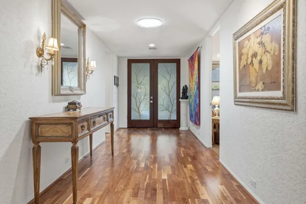 a view of a hallway with wooden floor and a bathroom