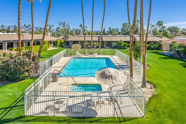 a view of swimming pool with seating area and yard in the back
