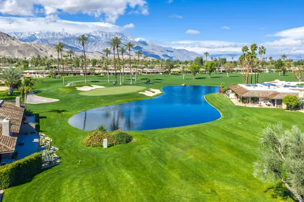 an aerial view of a house with swimming pool big yard and a fountain