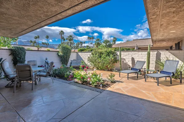 a view of a patio with table and chairs and potted plants