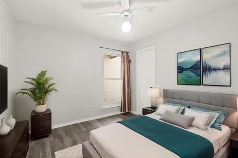 a bedroom with a large bed and a potted plant