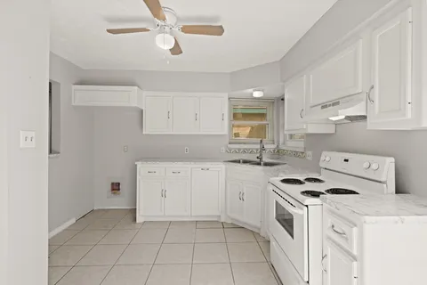 a kitchen with cabinets appliances a sink and a window