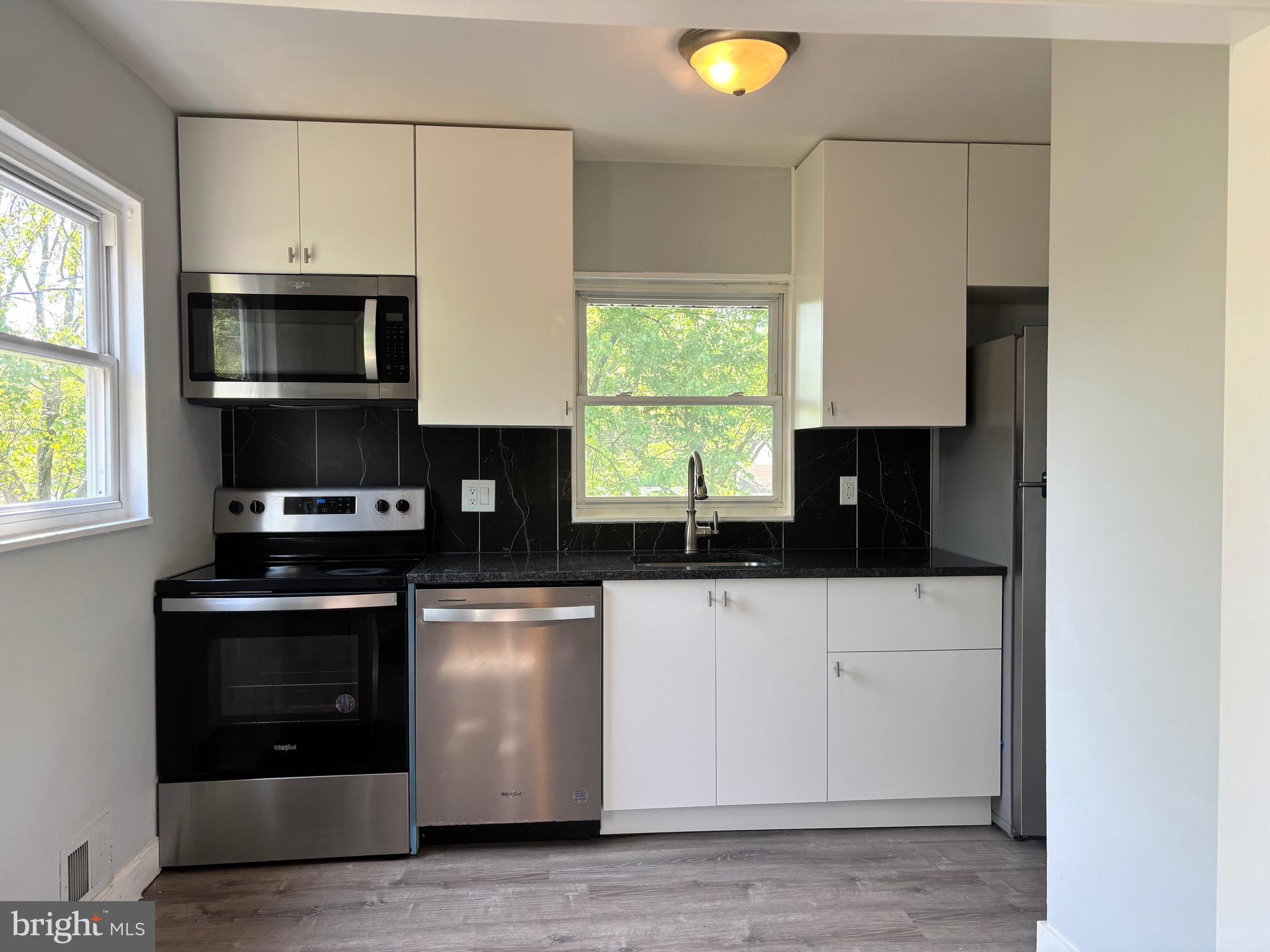 9103 Wallace Road Lanham, MD 20706 - Photo 11 of 30 a kitchen with stainless steel appliances a stove microwave and sink