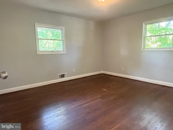 a view of a room with wooden floor and windows in it