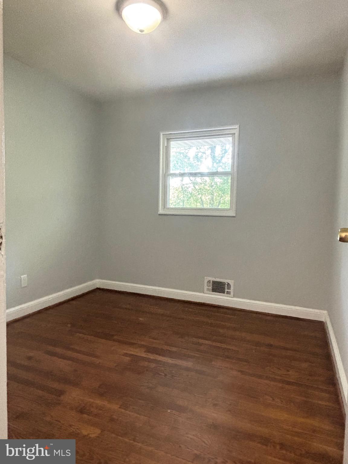 9103 Wallace Road Lanham, MD 20706 - Photo 14 of 30 a view of an empty room with wooden floor and a window