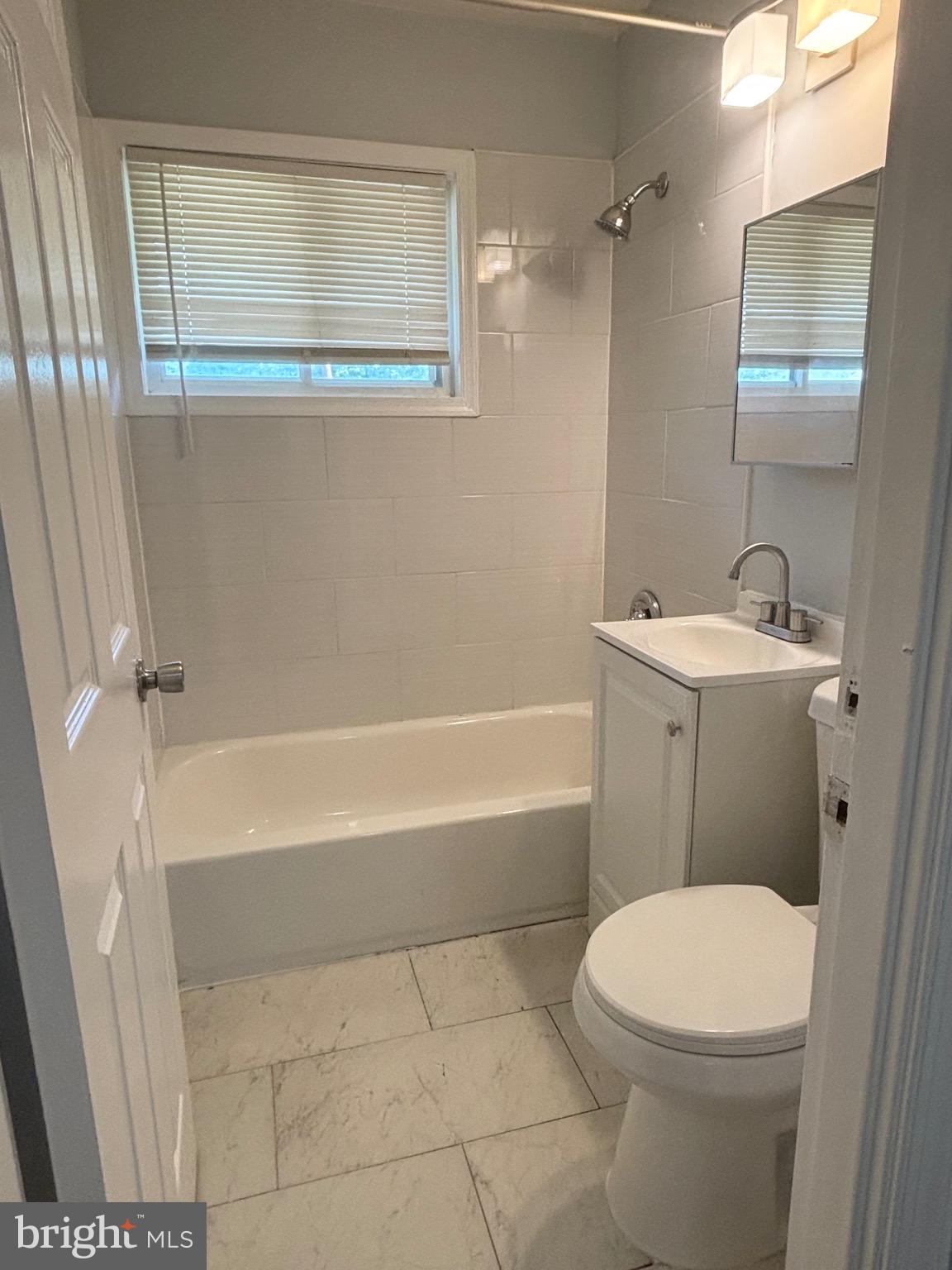 9103 Wallace Road Lanham, MD 20706 - Photo 15 of 30 a bathroom with a sink a toilet and shower