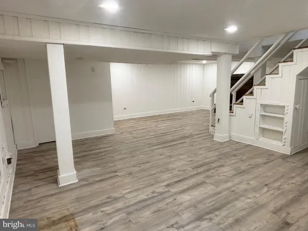 a view of a livingroom with wooden floor and stairs