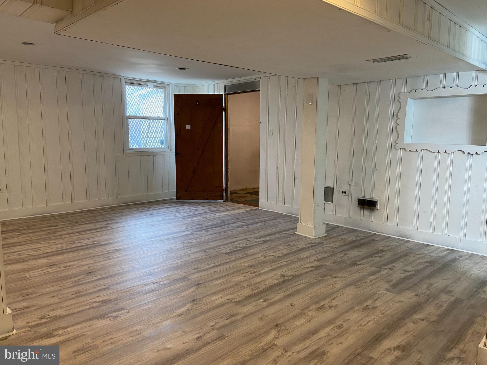 9103 Wallace Road Lanham, MD 20706 - Photo 20 of 30 a view of an empty room with wooden floor and a window