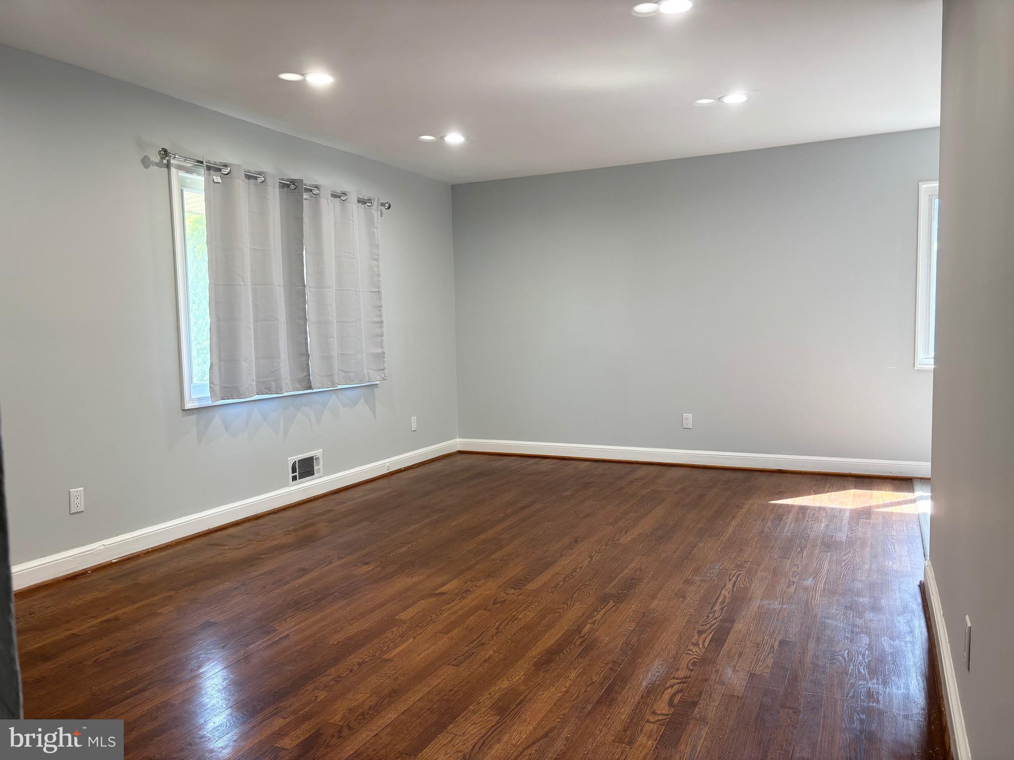9103 Wallace Road Lanham, MD 20706 - Photo 2 of 30 an empty room with wooden floor and windows