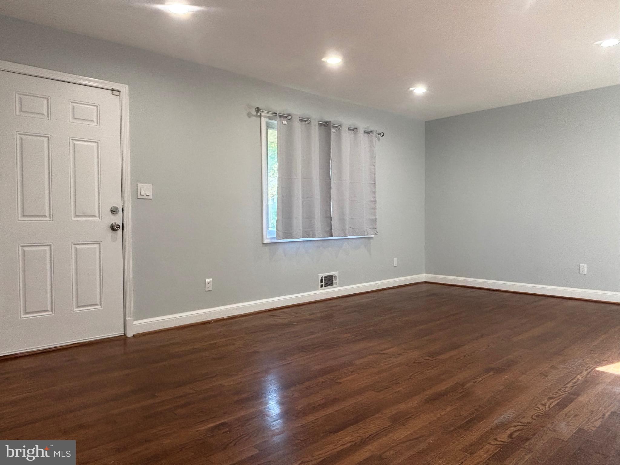 9103 Wallace Road Lanham, MD 20706 - Photo 3 of 30 a view of an empty room with wooden floor and a window
