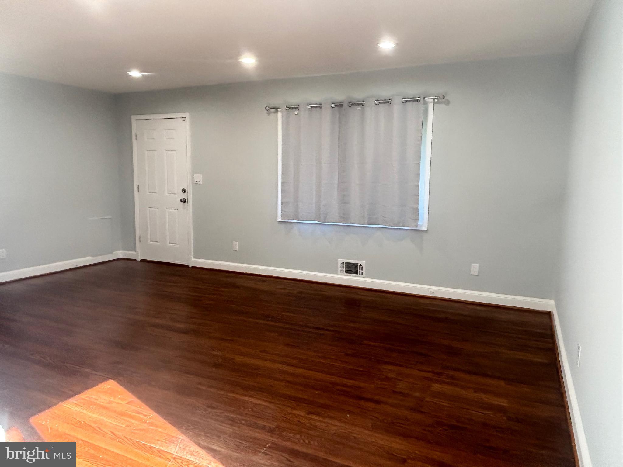 9103 Wallace Road Lanham, MD 20706 - Photo 4 of 30 a view of an empty room with wooden floor and a window