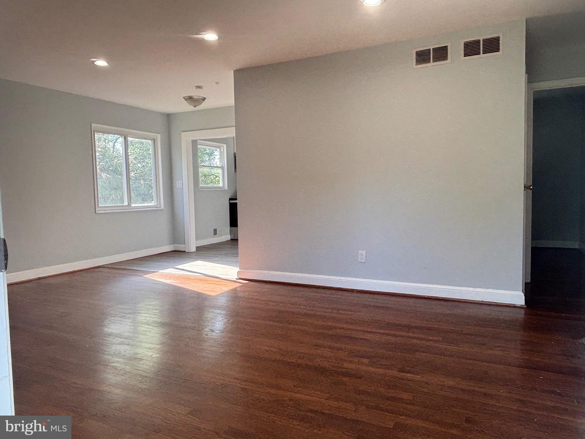 9103 Wallace Road Lanham, MD 20706 - Photo 6 of 30 an empty room with wooden floor and windows