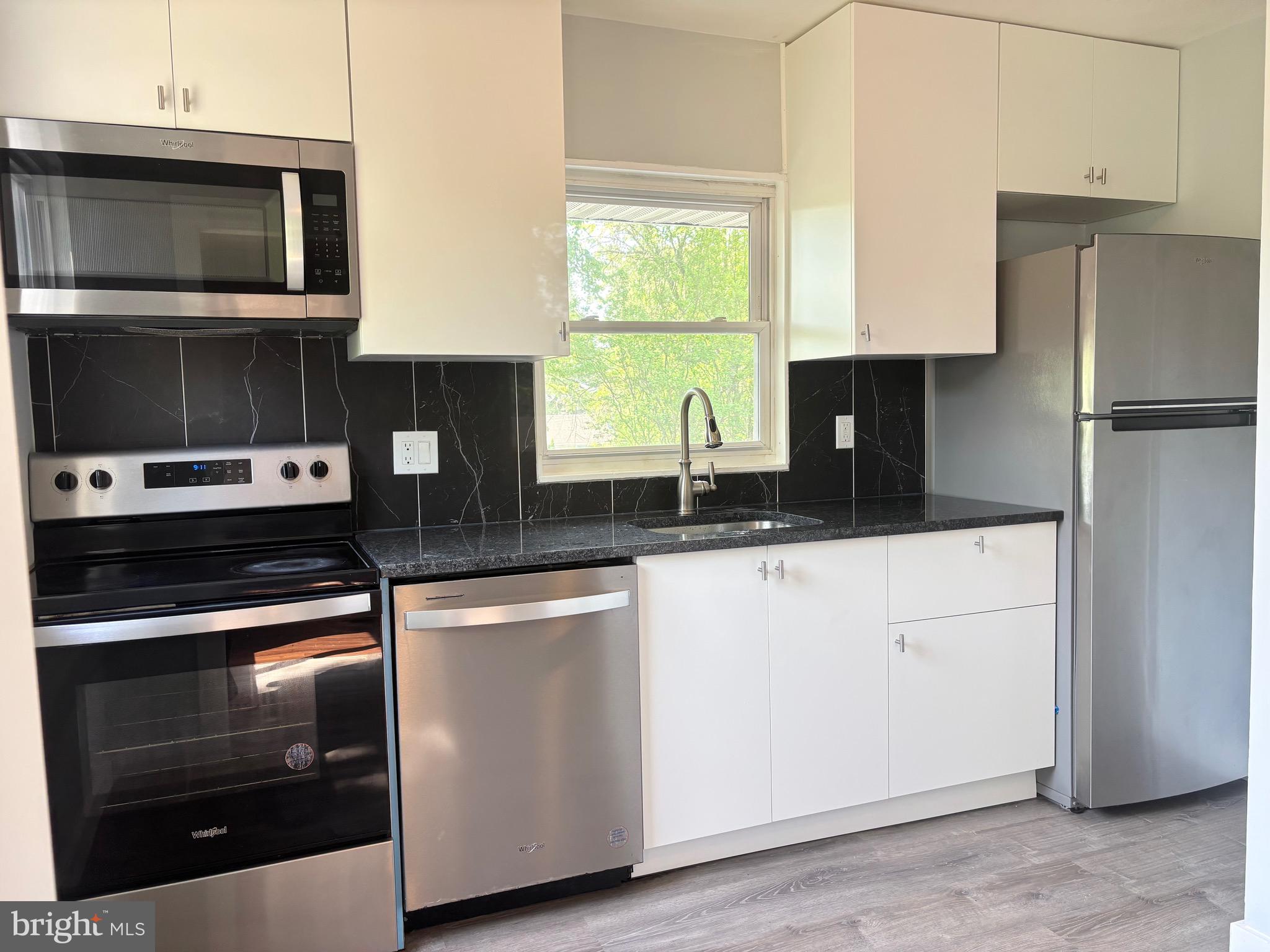 9103 Wallace Road Lanham, MD 20706 - Photo 7 of 30 a kitchen with a refrigerator stove and microwave