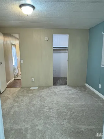 an empty room with closet and windows